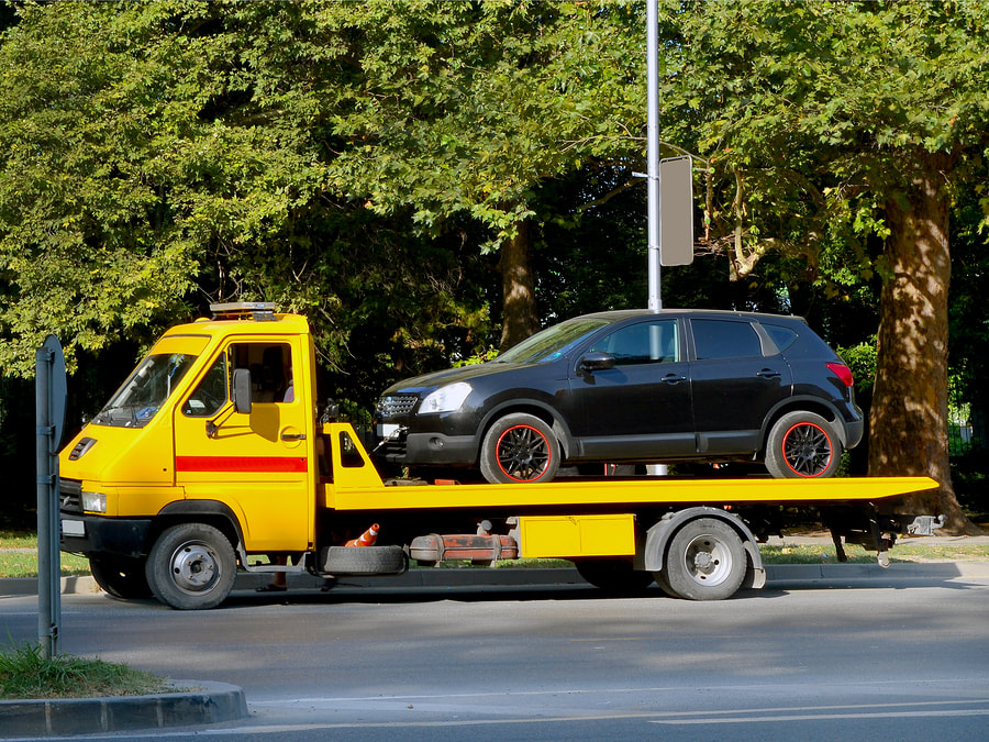 a yellow flatbed tow truck 