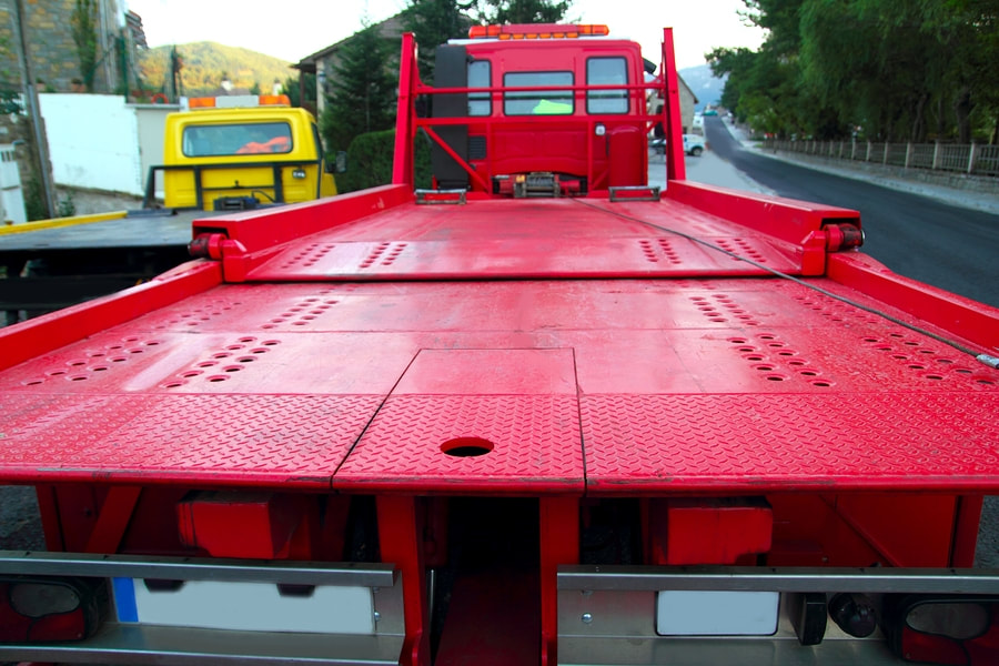 the bed of a large red flatbed tow truck